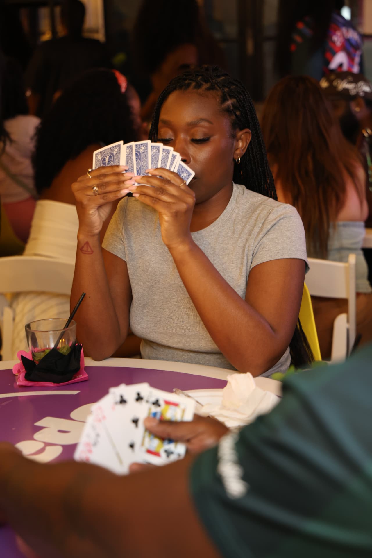 Guest holding playing cards at a full table