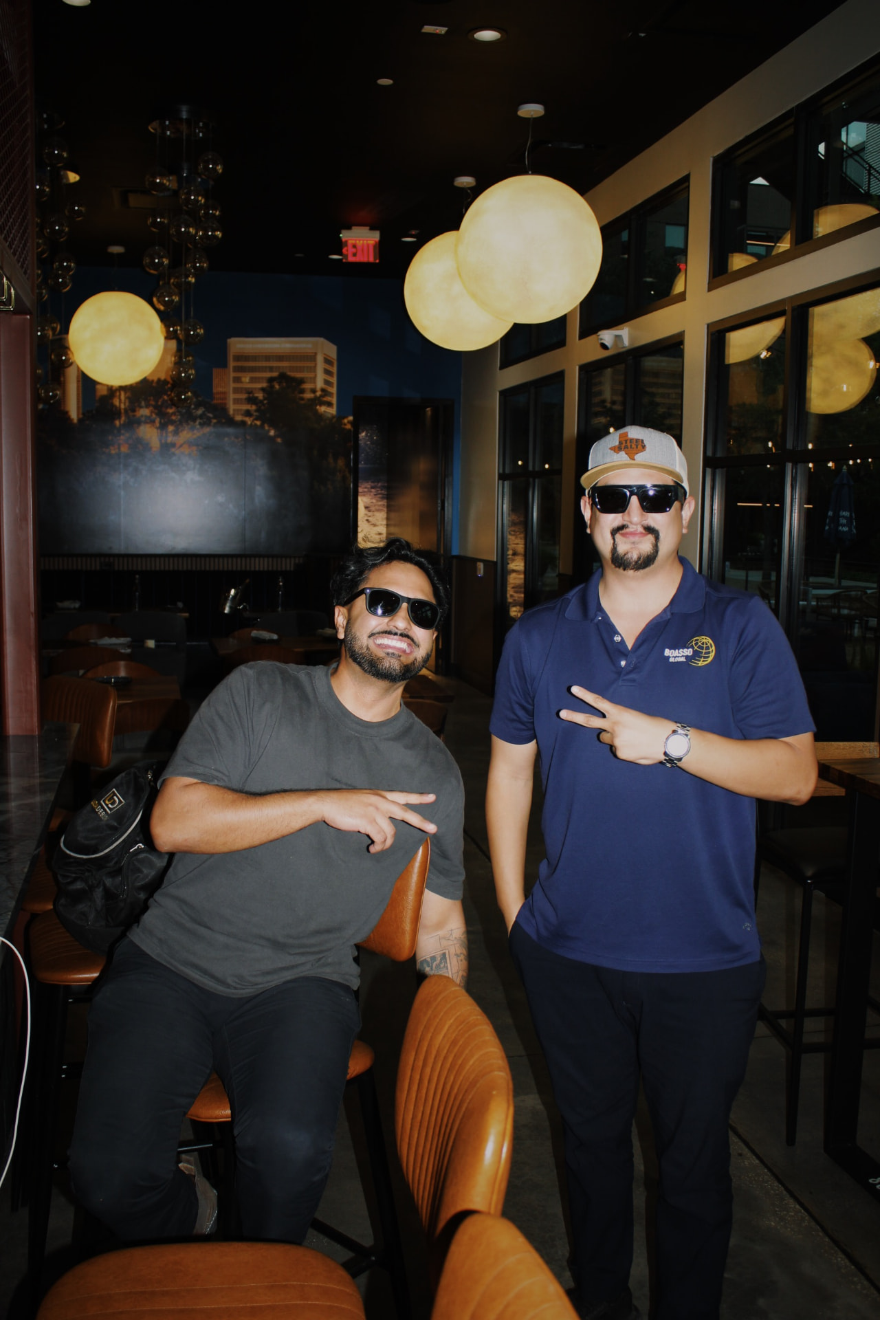 Two guests in sunglasses posing inside the venue